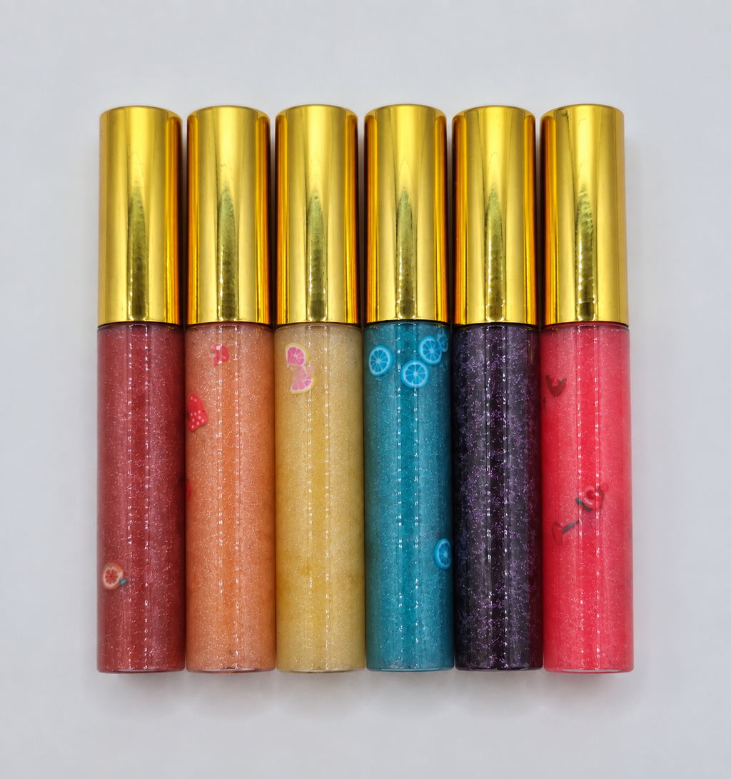 Fruity Pop Naturals shimmer lip gloss collection with gold caps, glitter, and decorative charms